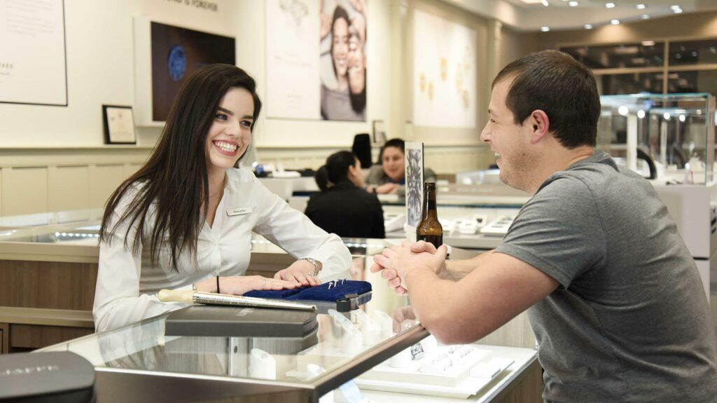 Buyer talking to jeweler at a counter with gemstones displayed